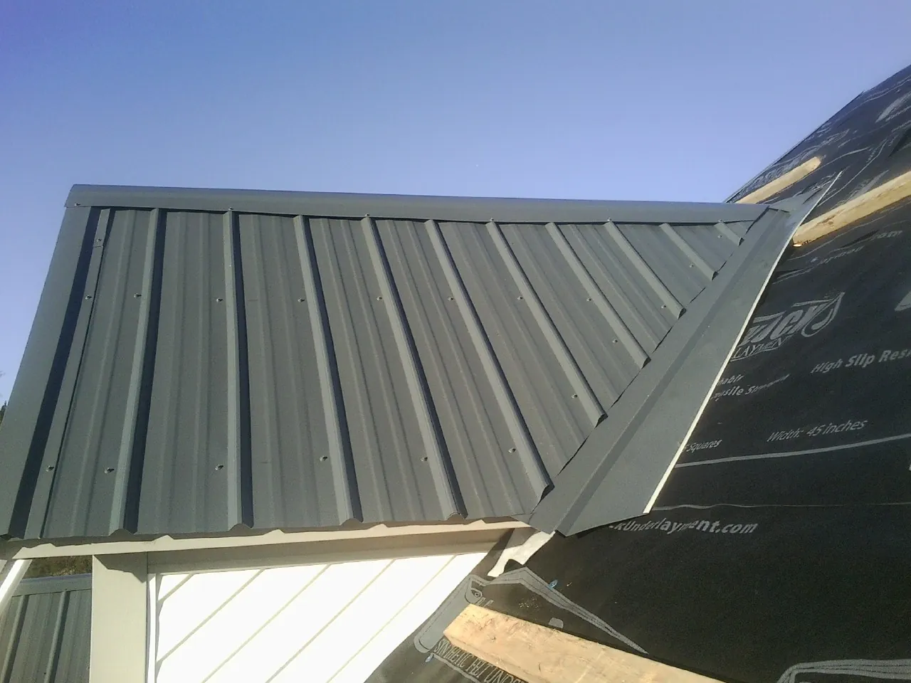 Gray metal roof panels going on over a garage gable in Blenheim