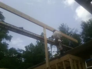 Carpenter setting a ridge beam over a new addition frame — Ice Dam Removal by Roofing Brothers in Blenheim