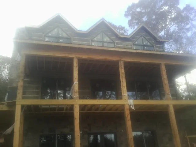 Dormers and porch framing on a large log home under construction — Roof Coating work by our crew in Blenheim